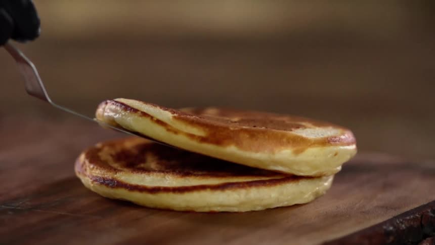 A person sets a pancake down