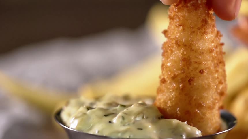Fried shrimp is dunked into a creamy dill sauce