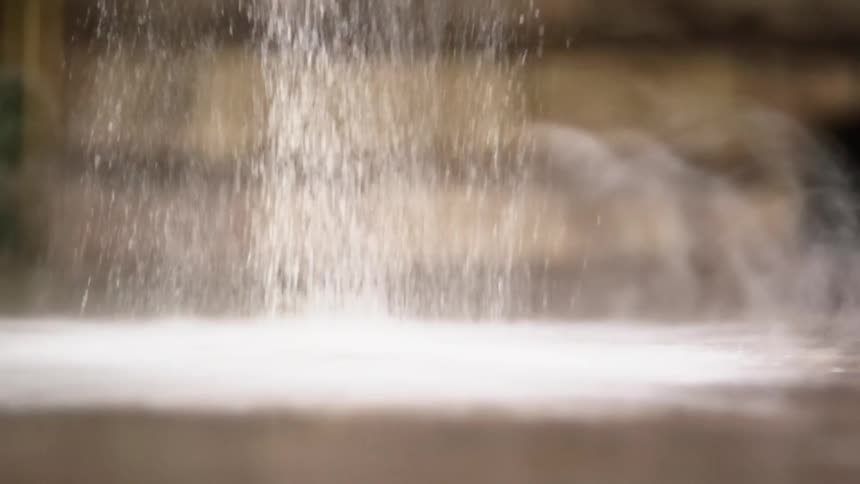 White flour pours down on a wooden table