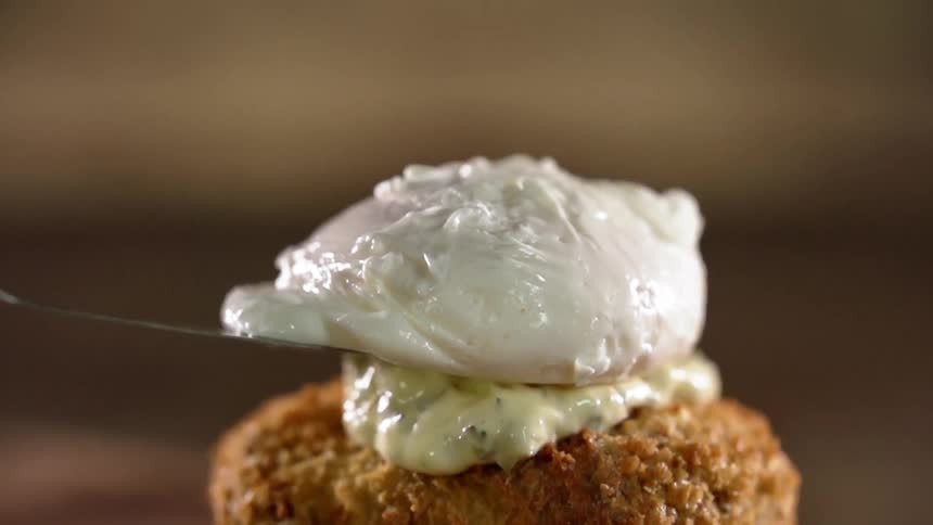 White icing is added to the top of a baked good