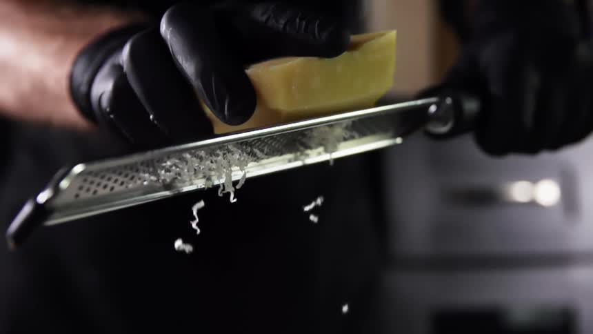 A person is grating cheese