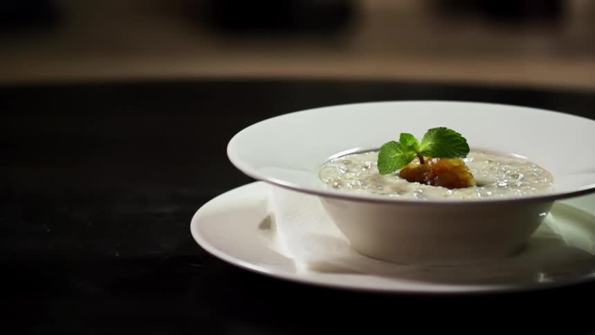 A garnish is set on top of a bowl of food