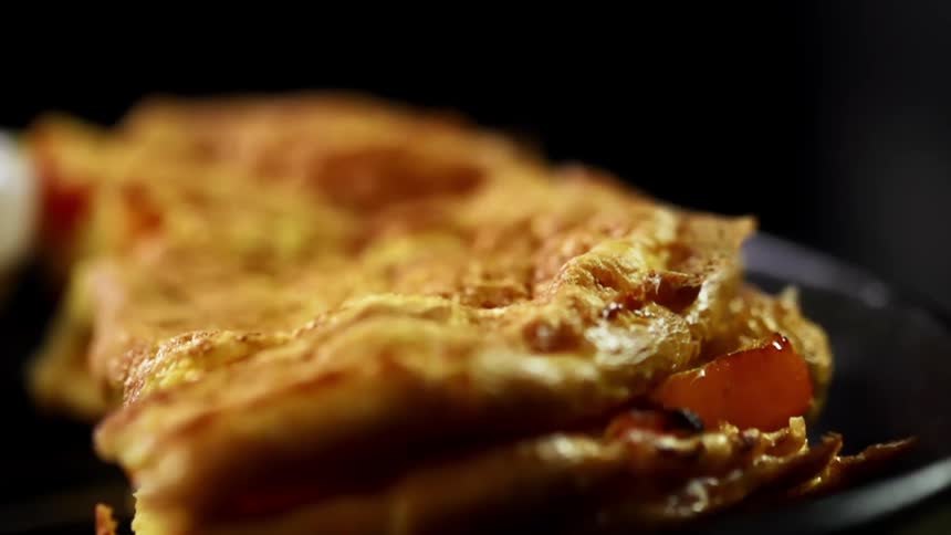 A person puts an omelet on a plate