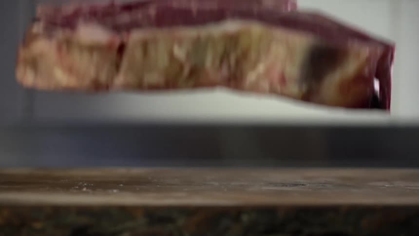 Raw beef falls on the wooden countertop