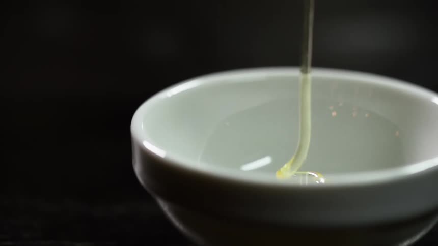 Sauce is pouring into the porcelain bowl