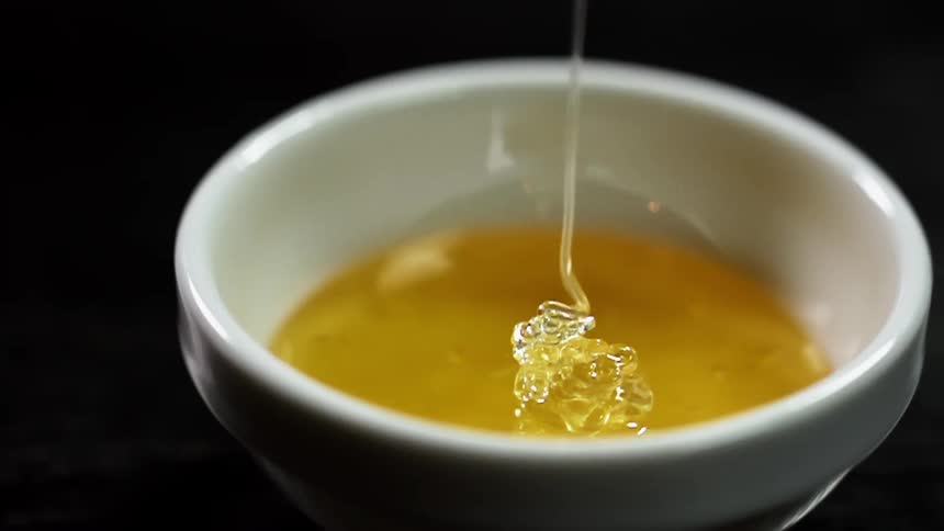 Honey is being poured into a plate