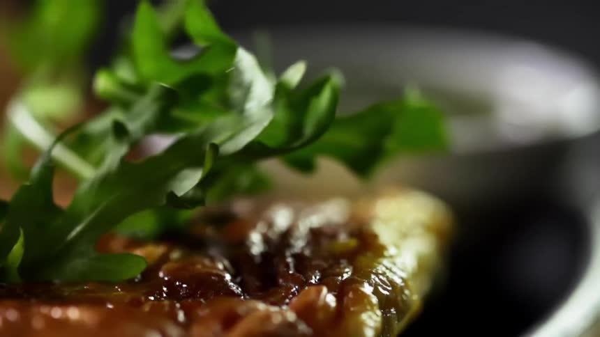 Greens are added to a plate of omelette, salmon and bread