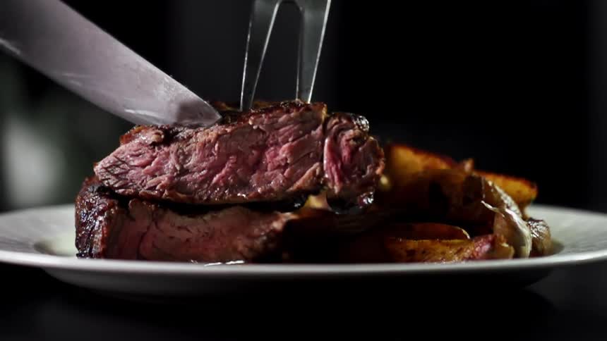 Meat being set on a plate