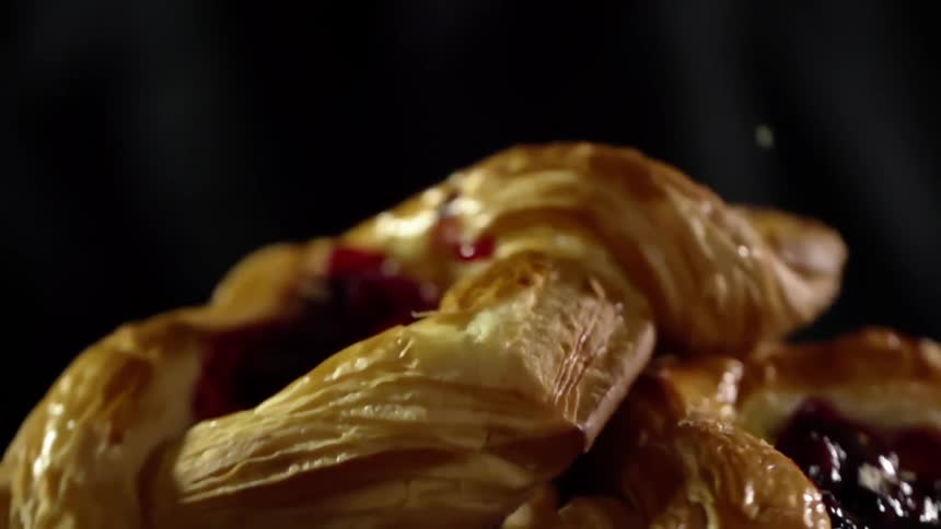 Puff pastry sweets filled with jam falls on a pile of other pastries