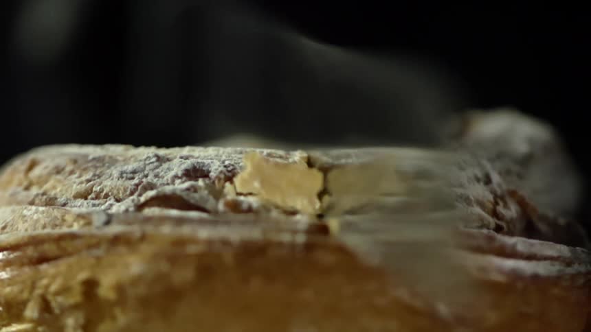 A knife cutting bread with crumbs