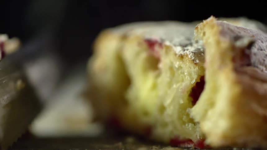 A knife sliced through a danish which is then pulled apart