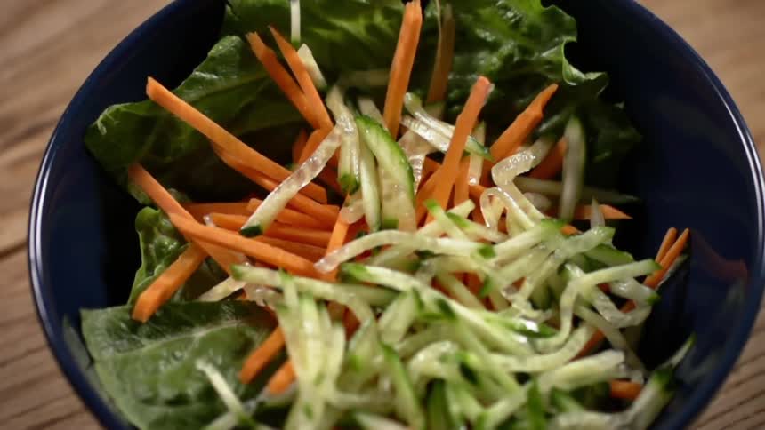 Sprouts tumble into a salad in a bowl