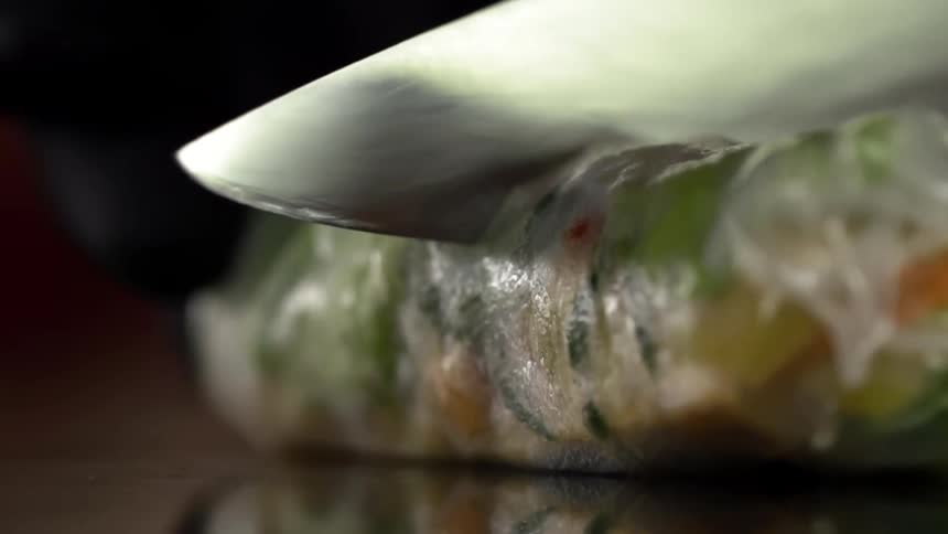 A spring roll being cut in half