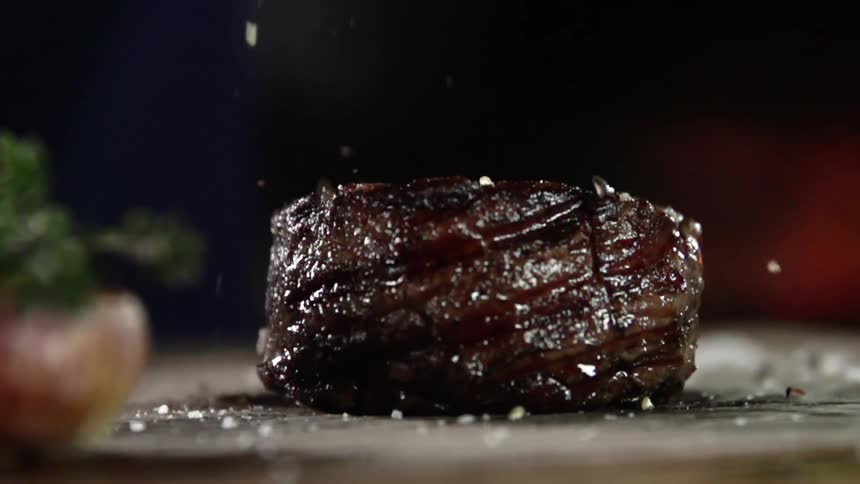 Seasoning is dropped on a steak