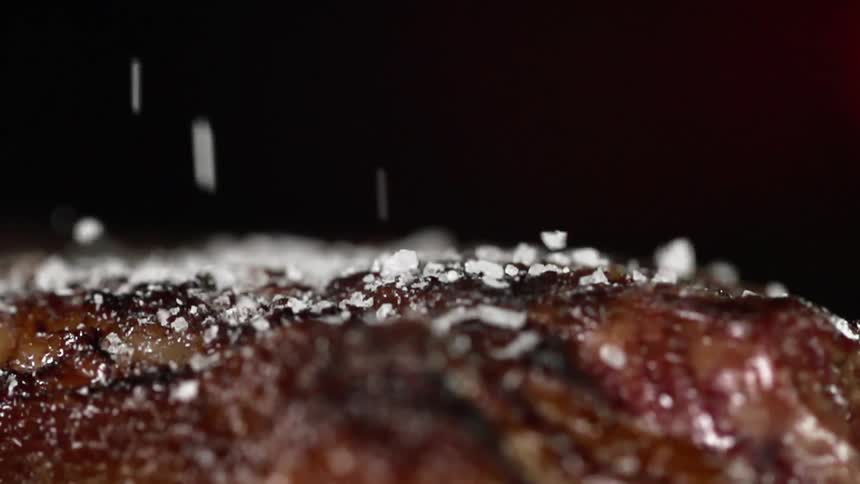 Juicy steak is being added salt