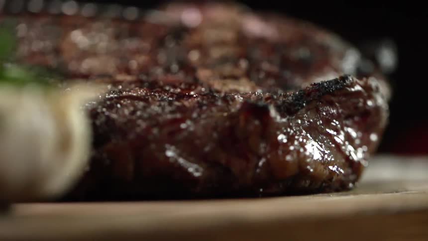 A piece of meat being set on a cutting board