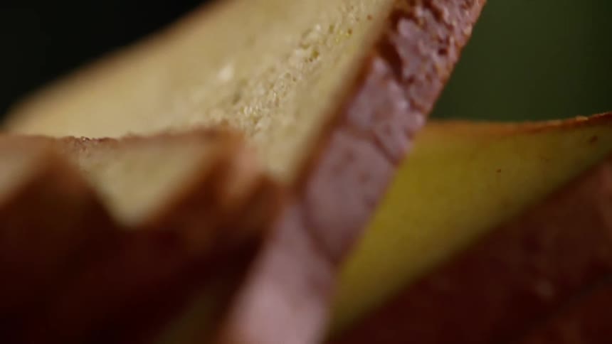 A person lifts a slice of bread