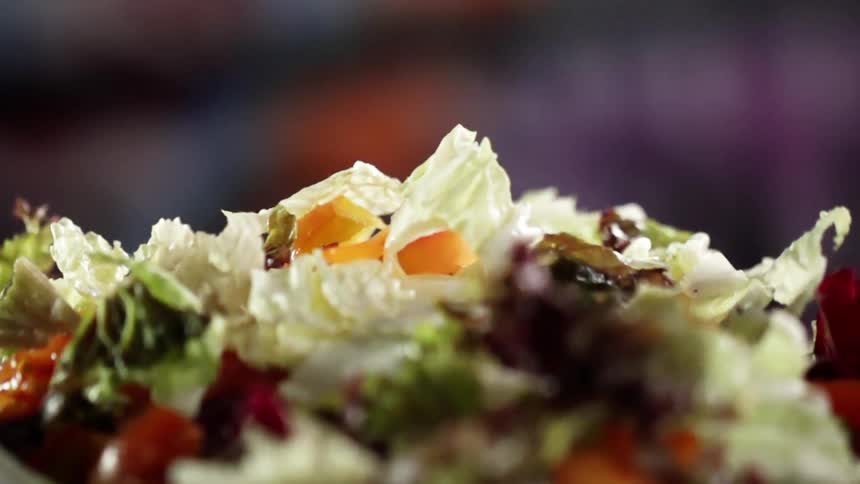 Lettuce and other salad ingredients are poured into a bowl