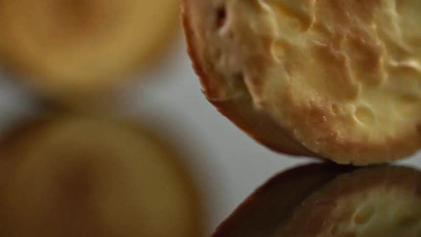Round baked goods rotate on a reflective surface