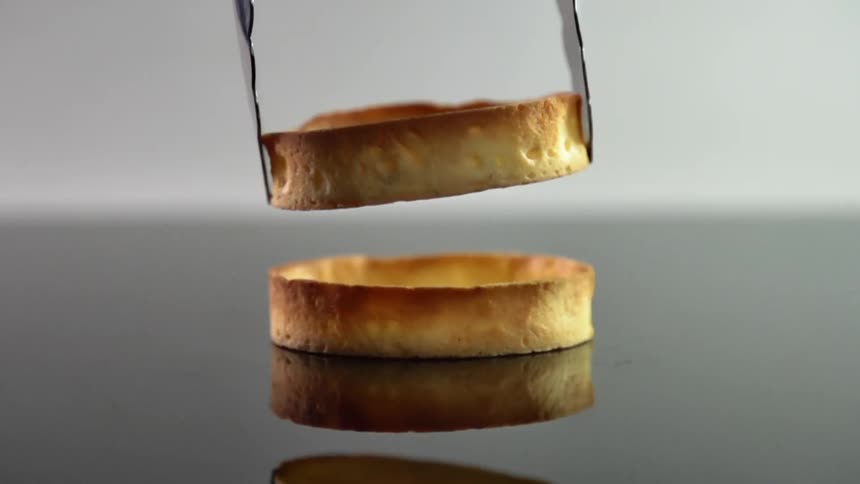 A pastry shell is lowered on to another pastry shell
