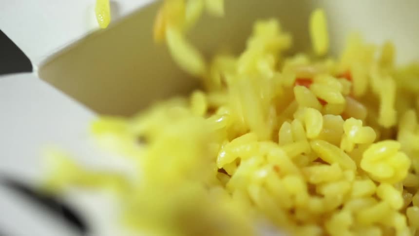 Cooked rice falls into a takeout container