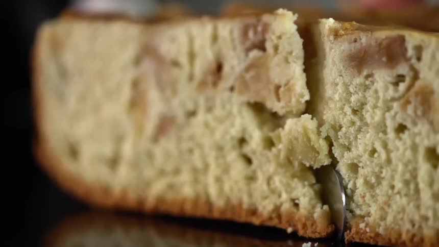 Close up of a baked delicious cake being cut by a sharp knife