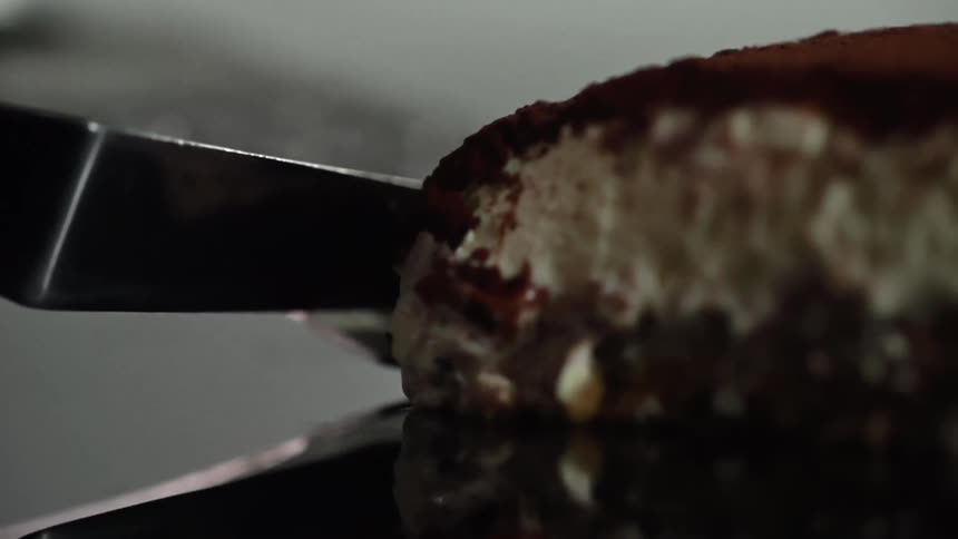 A piece of tiramisu on a reflective surface