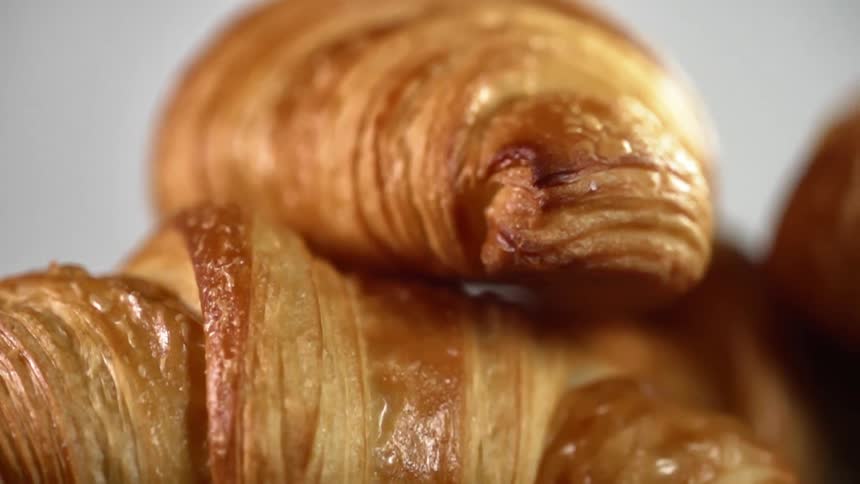 A stack of croissants are under the lights