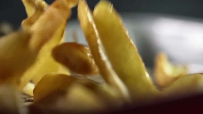 Long thin french fries fall in a tray