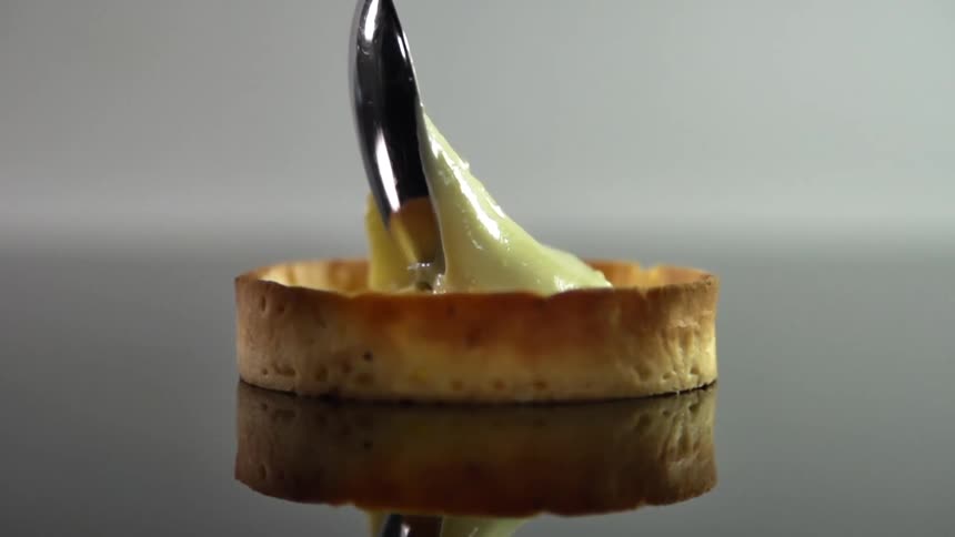 A tart shell is filled with yellow custard