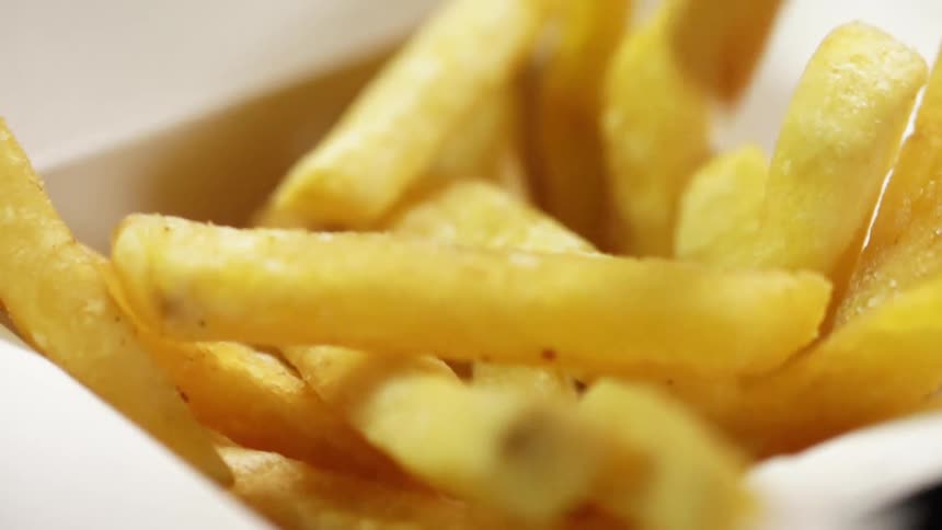 French fries are dropped into a container