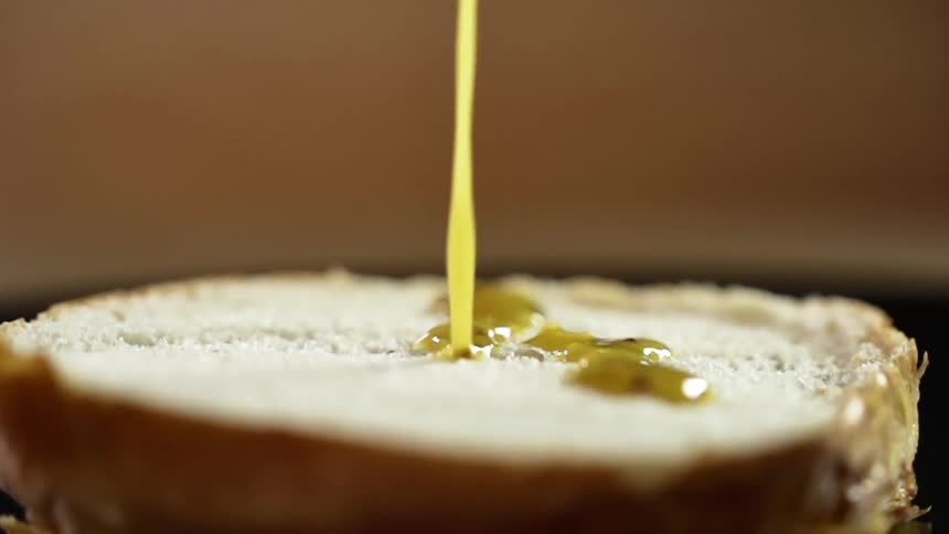 Sauce is poured onto a half of hamburger bun
