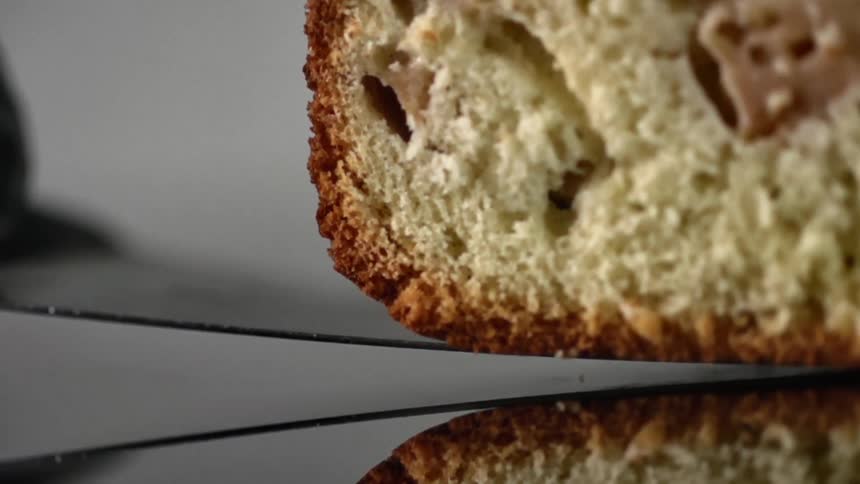 A piece of bread is lifted with a knife