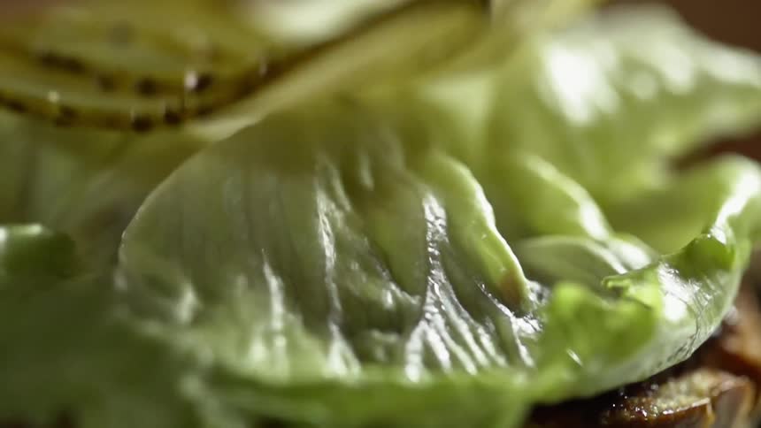 Pickles falling onto lettuce