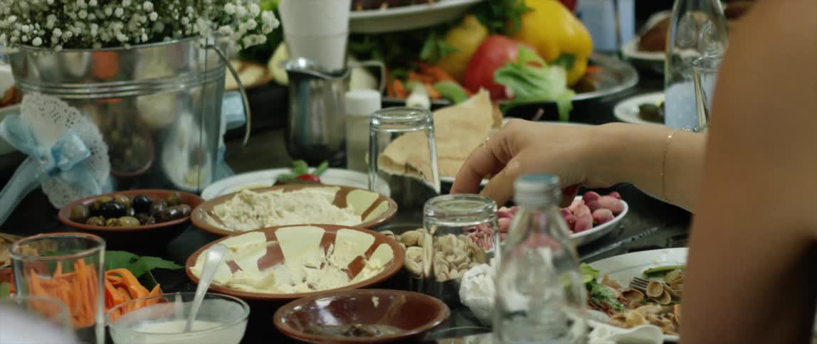 A woman picks up food from a table