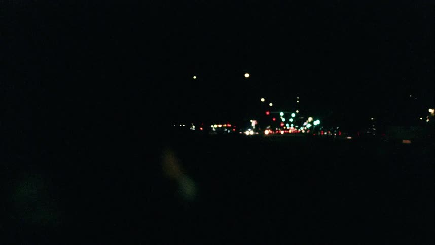A car is racing down the road at night