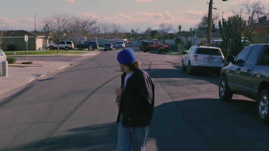 A man is running down the neighborhood street