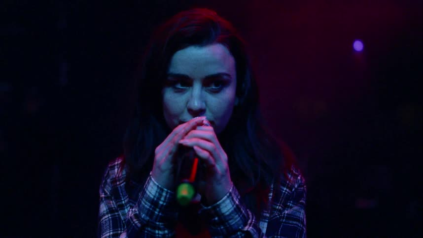 A young woman singing indoors