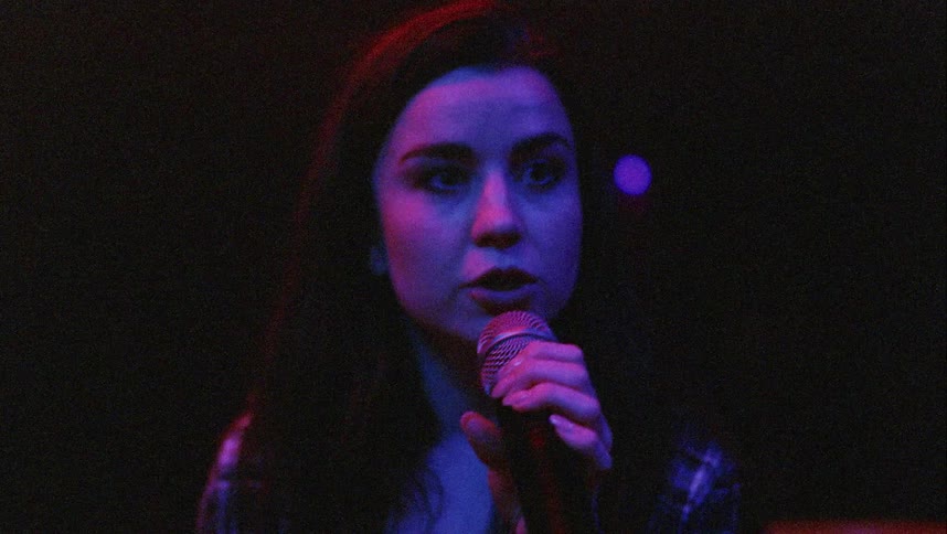 A young woman singing inside