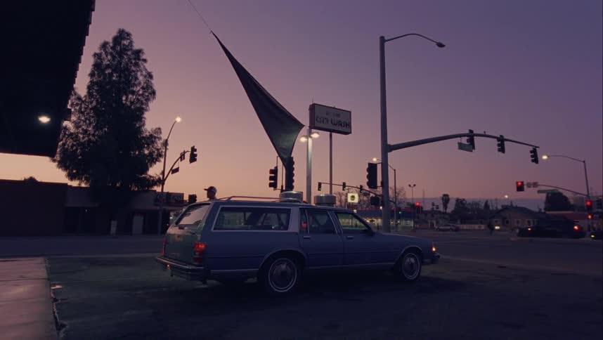 Cars drive through the intersection at sunset