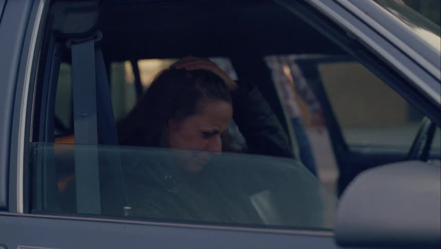 A man and woman sit in the car and as the woman cries the man gets out and a little boy sits in the back seat just looking out the window
