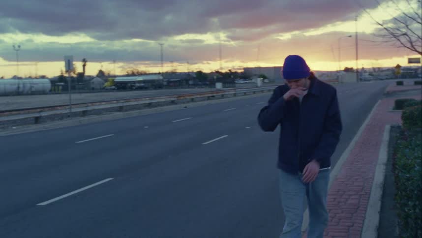 A man walks past the empty road