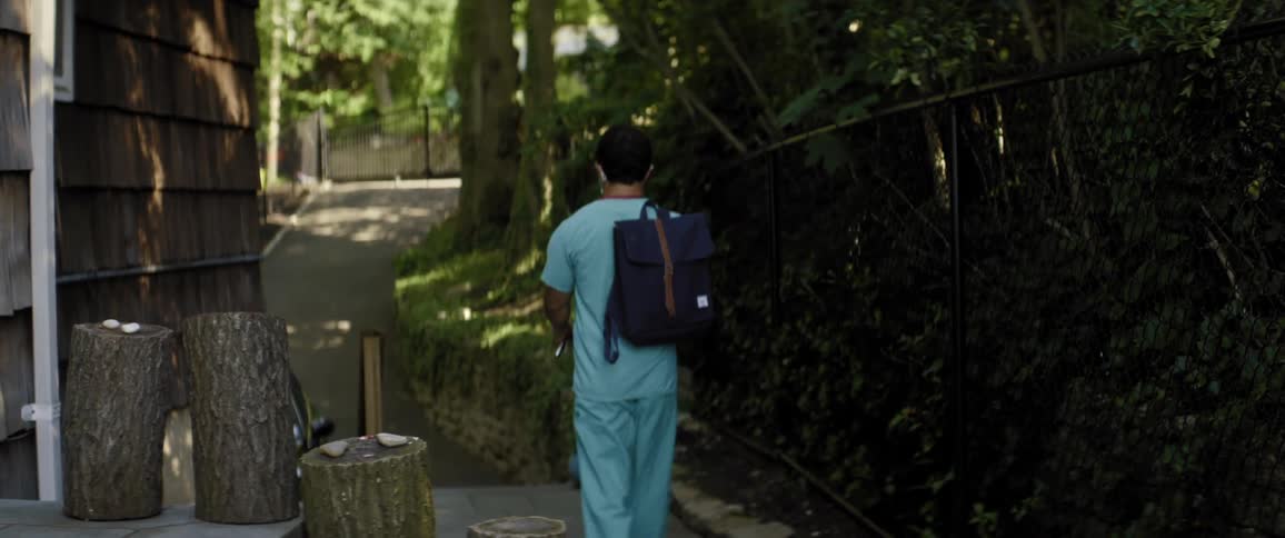 A man leaves his house in medical scrubs