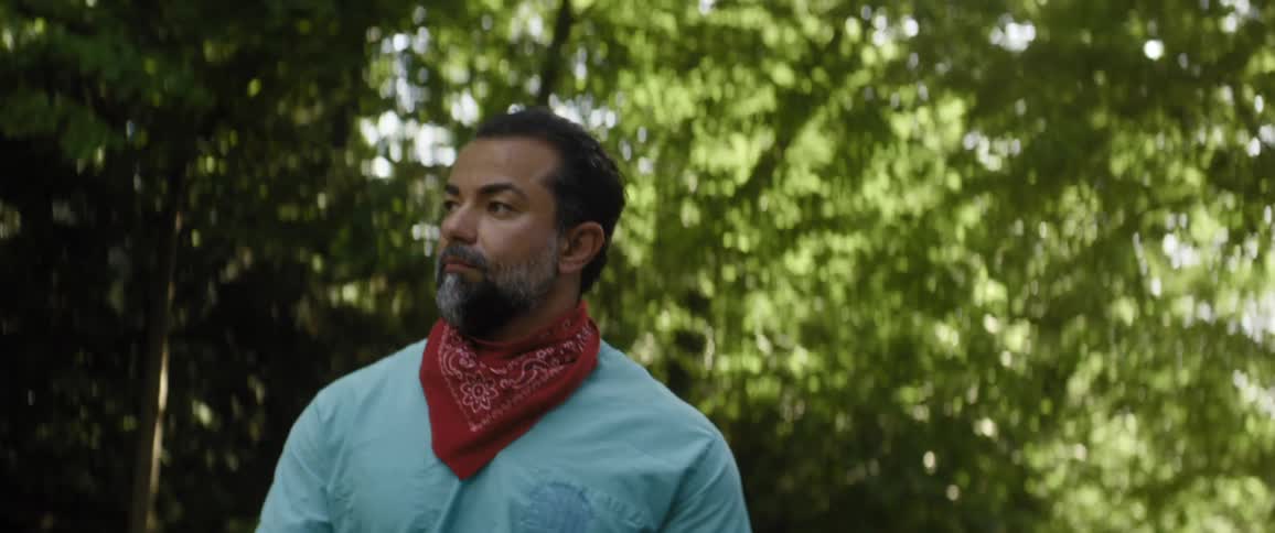 A man walking outside under trees