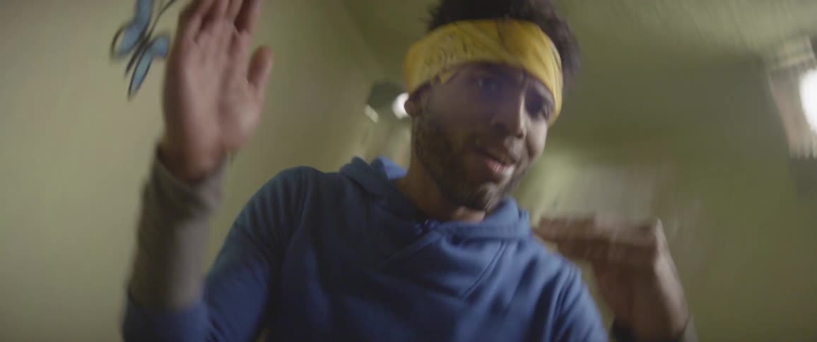 A man wearing a headband is dancing in a tunnel