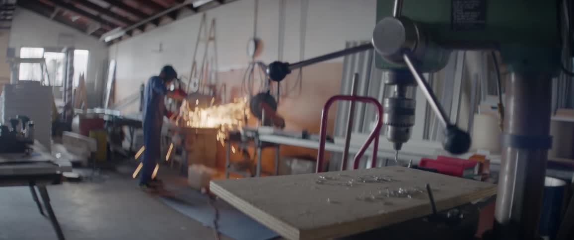 Sparks fly around a worker in a workshop