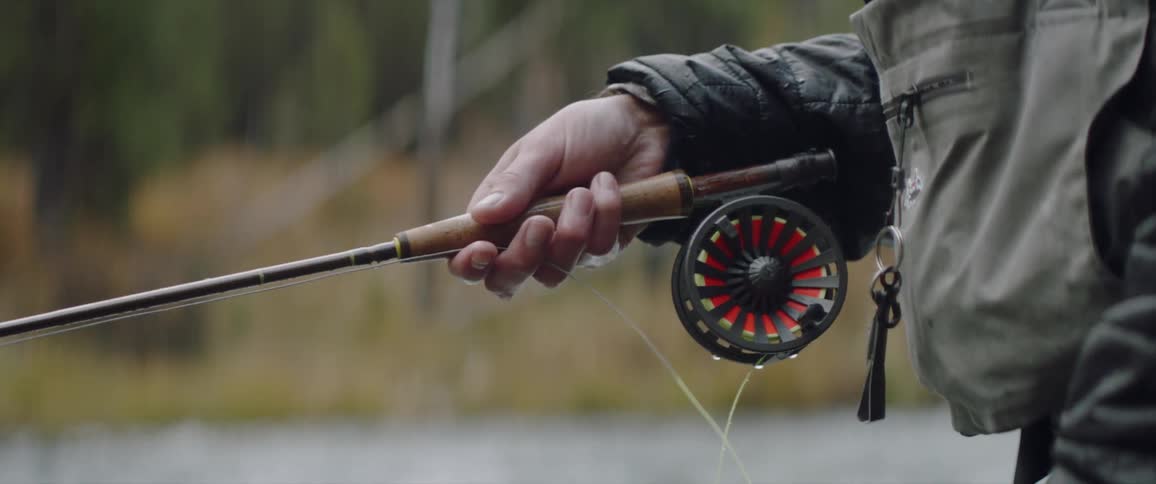 A person is reeling in his fishing line
