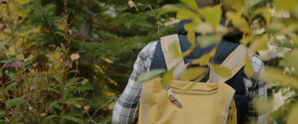 A woman is walking through the woods