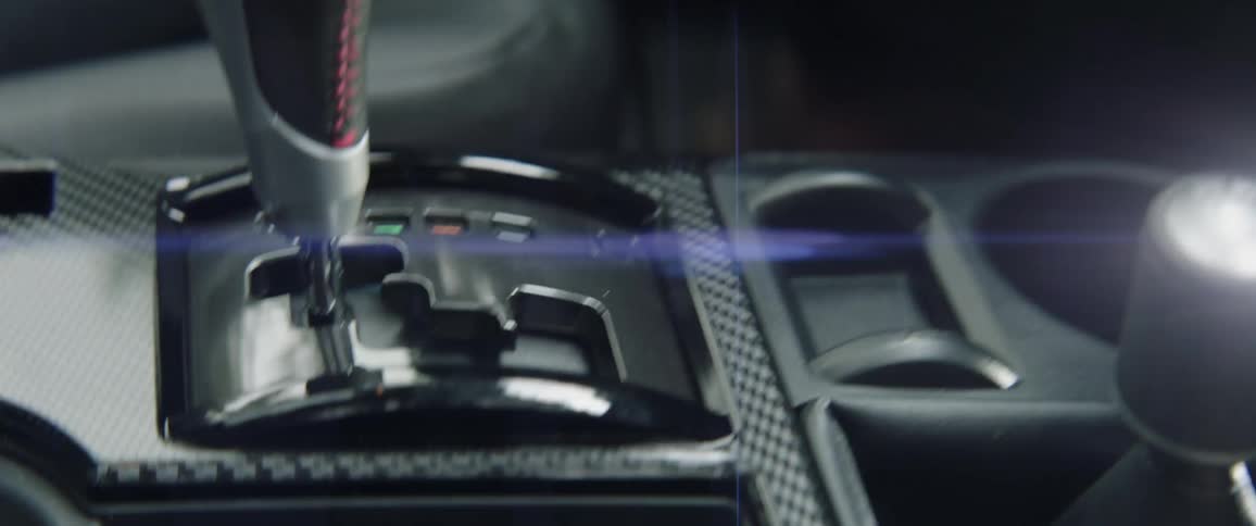 A woman is shifting gears in a vehicle during the day