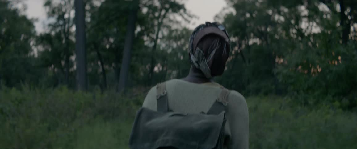 Woman hikes alone in a forest at sunset